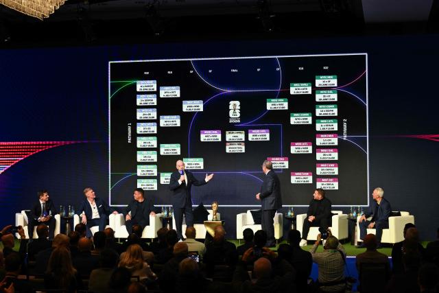 FIFA President Gianni Infantino (center-L) speaks as the screen displays the schedule during the FIFA World Cup 2026 official match schedule announcement in Washington, DC, on December 6, 2025. (Photo by Roberto SCHMIDT / AFP)