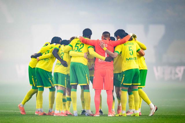 Nantes' players gather on the pitch prior to the French L1 football match between FC Nantes and RC Lens at the Stade de la Beaujoire–Louis Fonteneau in Nantes, western France, on December 6, 2025. (Photo by Loic VENANCE / AFP)
