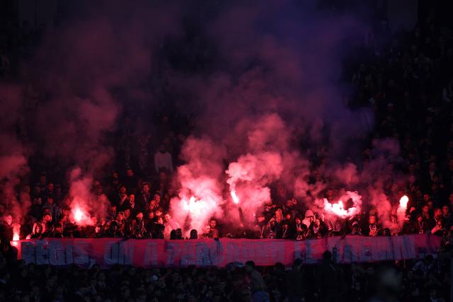 Toulouse's supporters light smoke bombs to pay tribute to a departing TFC staff member during the French L1 football match between Toulouse FC and RC Strasbourg Alsace at the TFC Stadium in Toulouse, southwestern France, on December 6, 2025. (Photo by Valentine CHAPUIS / AFP)