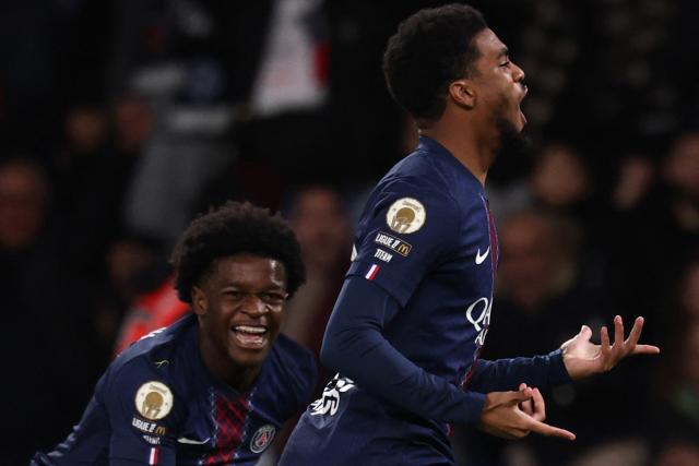 Paris Saint-Germain's French forward #49 Ibrahim Mbaye (R) celebrates scoring his team's fourth goal with Saint-Germain's French forward #47 Quentin Enzo Leo Ndjantou Mbitcha during the French L1 football match between Paris Saint-Germain (PSG) and Stade Rennais FC at the Parc des Princes stadium in Paris on December 6, 2025. (Photo by FRANCK FIFE / AFP)