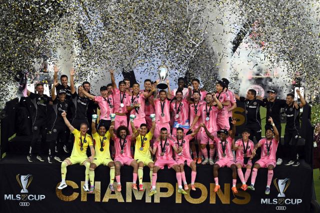 Inter Miami's Argentine forward #10 Lionel Messi (C) lifts the trophy as the team celebrate winning the Major League Soccer (MLS) Cup final between Inter Miami and the Vancouver Whitecaps at Chase Stadium in Fort Lauderdale, Florida, on December 6, 2025. (Photo by Chandan Khanna / AFP)