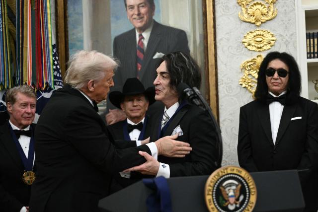 Kennedy Centre Honours recipient musician Paul Stanley of the rock band KISS, receives a medal from US President Donald Trump during the Kennedy Centre Honours medal presentation ahead of tomorrow's ceremony, in the Oval Office of the White House in Washington, DC, December 6, 2025. (Photo by Brendan SMIALOWSKI / AFP)