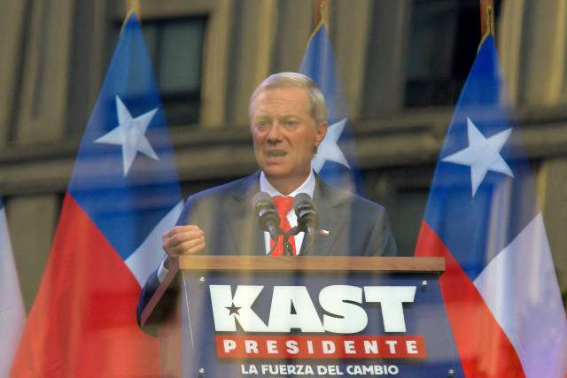 Chilean presidential candidate Jose Antonio Kast (C) of the Republican Party delivers a speech behind bulletproof glass during his closing campaign rally in Concepcion, Chile, on December 6, 2025. Chile will choose its next president in a runoff on December 14, with far-right candidate Jose Antonio Kast as the clear favorite against leftist Jeannette Jara, after a campaign marked by fears over crime and irregular migrants. (Photo by GUILLERMO SALGADO / AFP)