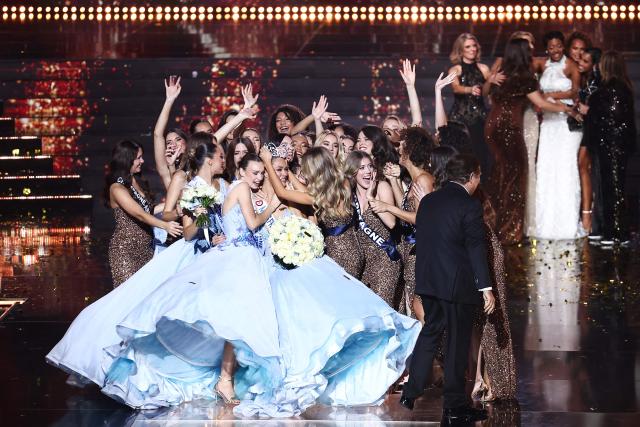Newly elected Miss France 2026 Miss Tahiti Hinaupoko Deveze (C) celebrates with the other competitors after winning the Miss France 2026 beauty pageant at the Zenith, in Amiens, northern France, on December 6, 2025. (Photo by Sameer AL-DOUMY / AFP)