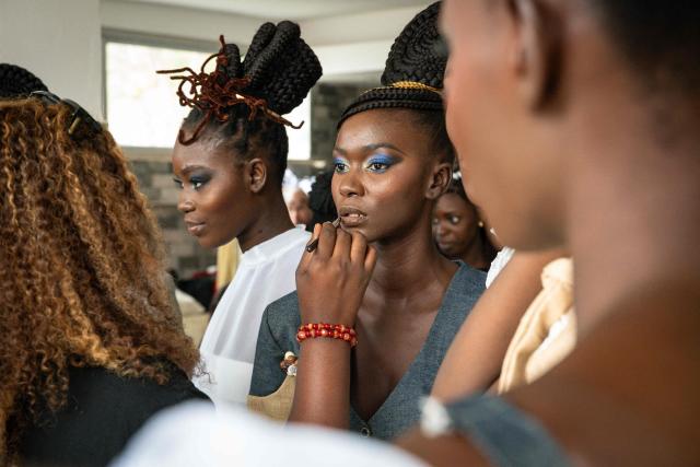 Models prepare backstage before the final show of the Dakar Fashion Week, which takes place aboard pirogues, in Ngor Bay, Dakar, Senegal, on December 6, 2025. (Photo by NICOLAS REMENE / AFP)