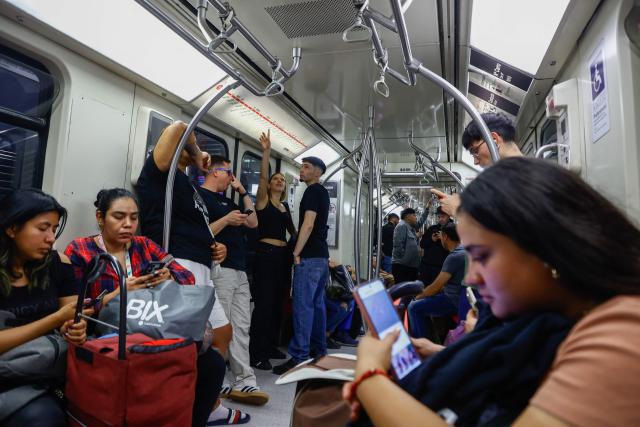 Passengers travel in a subway car in Santiago, eight days before the presidential runoff election, on December 6, 2025. Chile will choose its next president in a runoff on December 14, with far-right candidate Jose Antonio Kast as the clear favorite against leftist Jeannette Jara, after a campaign marked by fears over crime and irregular migrants. (Photo by Raul BRAVO / AFP)