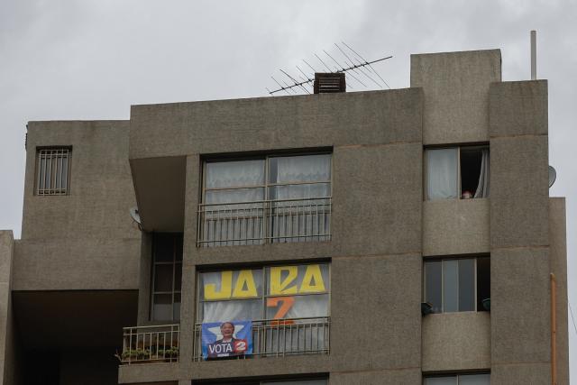 A poster supporting Chilean presidential candidate Jeannette Jara of the Unidad por Chile coalition is seen on an apartment window in downtown Santiago on December 6, 2025, eight days before the runoff election. Chile will choose its next president in a runoff on December 14, with far-right candidate Jose Antonio Kast as the clear favorite against leftist Jeannette Jara, after a campaign marked by fears over crime and irregular migrants. (Photo by Raul BRAVO / AFP)