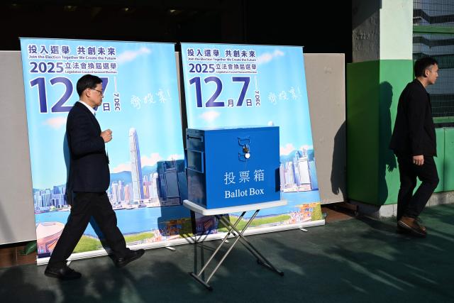 Hong Kong Chief Executive John Lee (L) casts his vote in the Legislative Council elections in Hong Kong on December 7, 2025. (Photo by Peter PARKS / AFP)