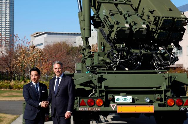 Japanese Defence Minister Shinjiro Koizumi (L) poses with Australian Defence Minister Richard Marles in front of a Patriot Advanced Capability-3 (PAC-3) missile interceptor unit at the Defense Ministry in Tokyo on December 7, 2025. (Photo by Franck ROBICHON / POOL / AFP)