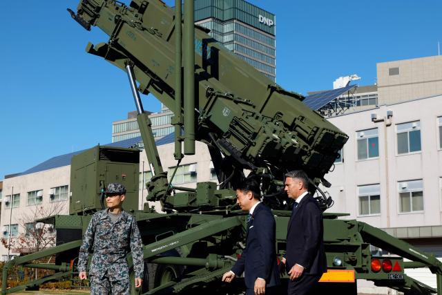 Japanese Defence Minister Shinjiro Koizumi (C) and Australian Defence Minister Richard Marles (R) inspect a Patriot Advanced Capability-3 (PAC-3) missile interceptor unit at the Defense Ministry in Tokyo on December 7, 2025. (Photo by Franck ROBICHON / POOL / AFP)