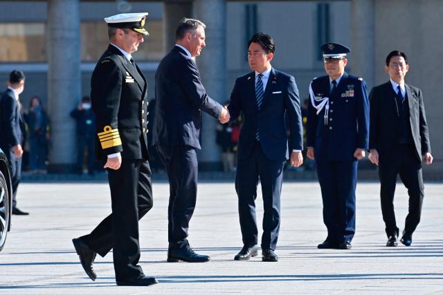 Japan’s Defence Minister Shinjiro Koizumi (C) shakes hands with Australia’s Defence Minister Richard Marles during a welcome ceremony at the Ministry of Defense in Tokyo on December 7, 2025. (Photo by David Mareuil / POOL / AFP)