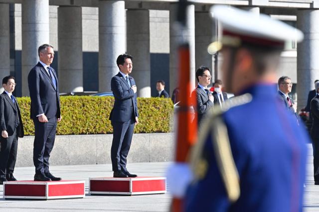 Japan’s Defence Minister Shinjiro Koizumi (C) and Australia’s Defence Minister Richard Marles (L) attend a welcome ceremony at the Ministry of Defense in Tokyo on December 7, 2025. (Photo by David Mareuil / POOL / AFP)