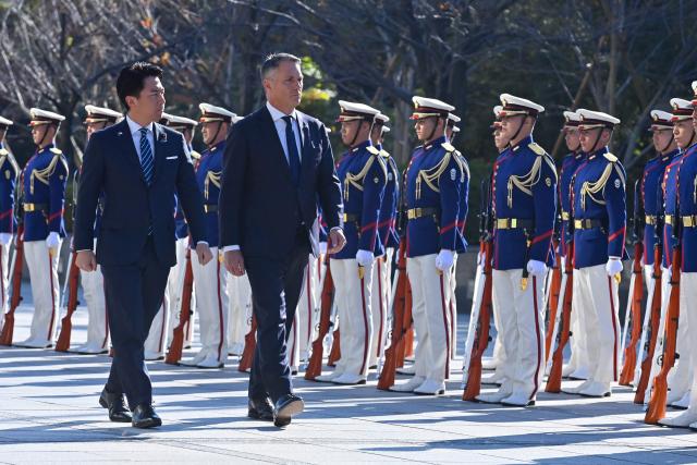Japan’s Defence Minister Shinjiro Koizumi (L) and Australia’s Defence Minister Richard Marles review honour guards during a welcome ceremony at the Ministry of Defense in Tokyo on December 7, 2025. (Photo by David Mareuil / POOL / AFP)