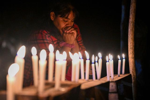 A relative of the victims holds a vigil following a boat accident at the port of Iparia, in the Ucayali department of Peru’s central jungle, on December 6, 2025. At least 12 people, including three children, died on December 1, 2025, when a landslide sank two boats docked at a river port in central Peru, with dozens of others missing, officials said. (Photo by Hugo Alejos / AFP)