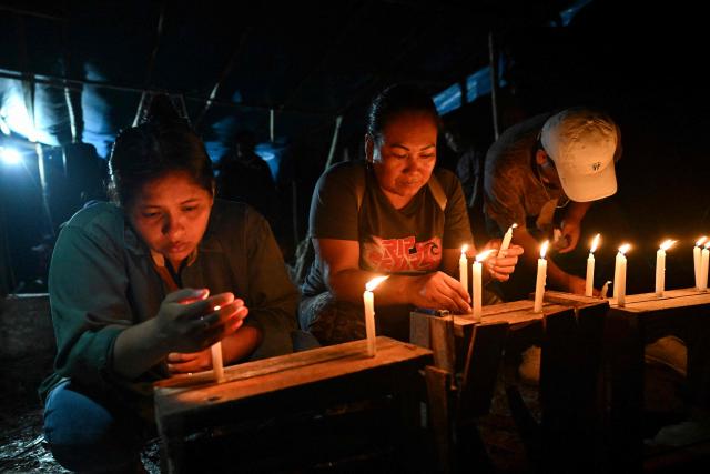 Relatives of the victims hold a vigil following a boat accident at the port of Iparia, in the Ucayali department of Peru’s central jungle, on December 6, 2025. At least 12 people, including three children, died on December 1, 2025, when a landslide sank two boats docked at a river port in central Peru, with dozens of others missing, officials said. (Photo by Hugo Alejos / AFP)