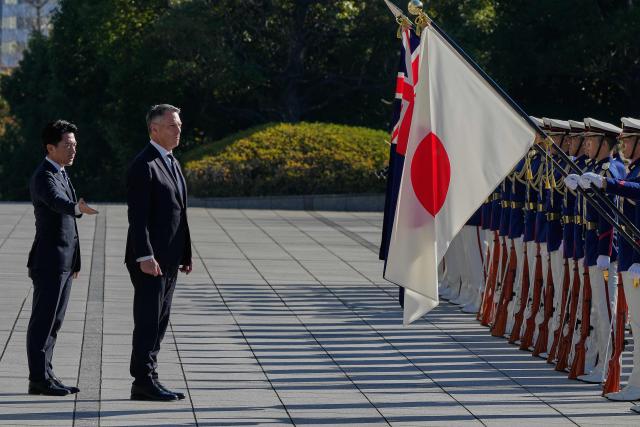 Japan’s Defence Minister Shinjiro Koizumi (L) and Australia’s Defence Minister Richard Marles review honour guards during a welcome ceremony at the Ministry of Defense in Tokyo on December 7, 2025. (Photo by Eugene Hoshiko / POOL / AFP)
