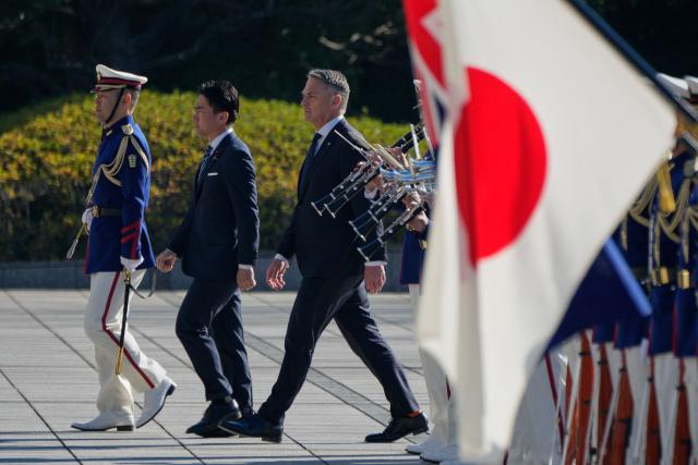 Japan’s Defence Minister Shinjiro Koizumi (C) and Australia’s Defence Minister Richard Marles review honour guards during a welcome ceremony at the Ministry of Defense in Tokyo on December 7, 2025. (Photo by Eugene Hoshiko / POOL / AFP)