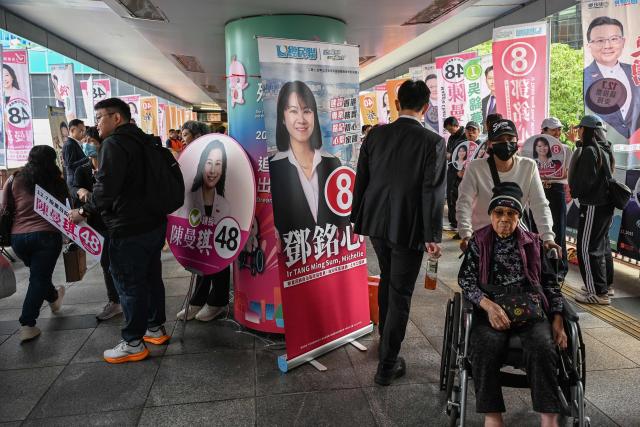 Supporters campaign for their candidates in the Legislative Council elections in Wanchai district of Hong Kong on December 7, 2025. (Photo by Peter PARKS / AFP)
