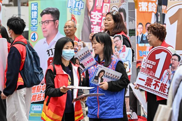Supporters campaign for their candidates in the Legislative Council elections in Wanchai district of Hong Kong on December 7, 2025. (Photo by Peter PARKS / AFP)