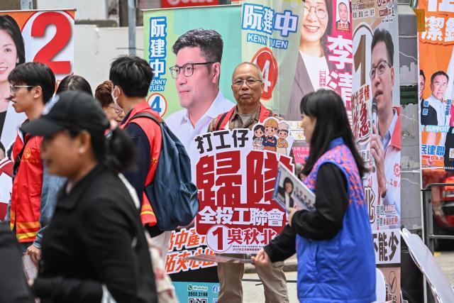 Supporters campaign for their candidates in the Legislative Council elections in Wanchai district of Hong Kong on December 7, 2025. (Photo by Peter PARKS / AFP)