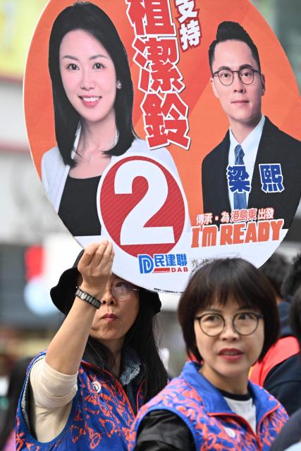Supporters campaign for their candidates in the Legislative Council elections in Wanchai district of Hong Kong on December 7, 2025. (Photo by Peter PARKS / AFP)