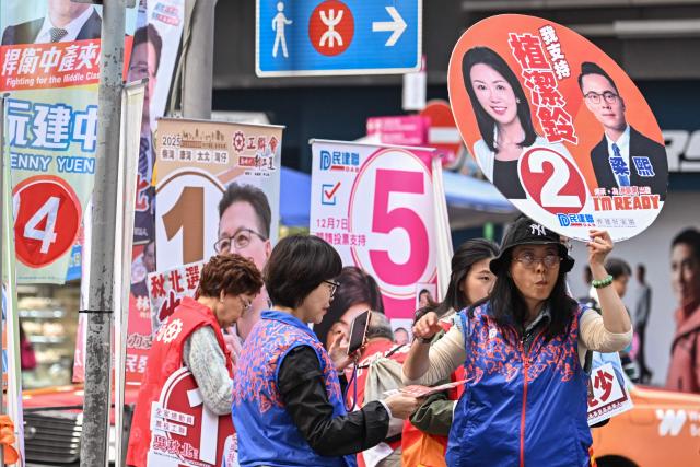 Supporters campaign for their candidates in the Legislative Council elections in Wanchai district of Hong Kong on December 7, 2025. (Photo by Peter PARKS / AFP)
