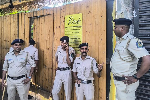 Police personnel stand guard outside a nightclub following a fire that broke out last midnight, in Goa on December 7, 2025. A fire that ripped through an Indian nightclub in the popular tourist resort region of Goa killed 25 people, the state's chief minister said on December 7. (Photo by AFP)