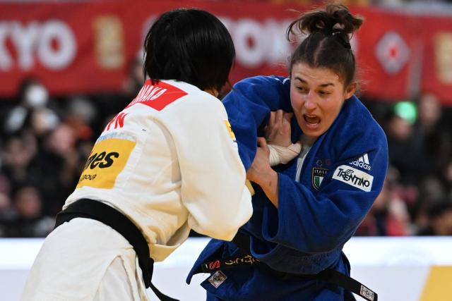 Japan's Shiho Tanaka (white) and Italy's Irene Pedrotti (blue) compete in the women's -70kg category quarter-final match at the Tokyo Grand Slam judo competition in Tokyo on December 7, 2025. (Photo by Toshifumi KITAMURA / AFP)