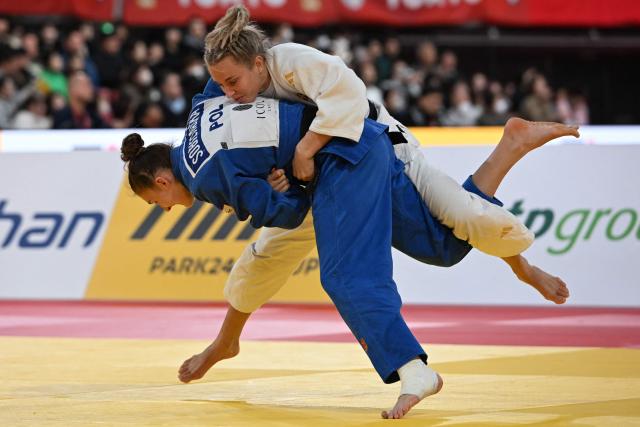 Sweden's Ida Eriksson (white) and Poland's Katarzyna Sobierajska (blue) compete in the women's -70kg category quarter-final match at the Tokyo Grand Slam judo competition in Tokyo on December 7, 2025. (Photo by Toshifumi KITAMURA / AFP)