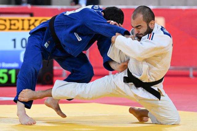 France's Luka Mkheidze (white) and France's Romain Valadier Picard (blue) compete in the men's -60kg category quarter-final match at the Tokyo Grand Slam judo competition in Tokyo on December 7, 2025. (Photo by Toshifumi KITAMURA / AFP)