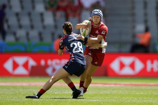 TOPSHOT - Japan's Yume Hirano is tackled by Britain's Solana Shaw de Leon during the 5th place Semi Final HSBC World Rugby Sevens Series women's rugby match between Japan and Great Britain at the DHL stadium in Cape Town on December 7, 2025. (Photo by GIANLUIGI GUERCIA / AFP)