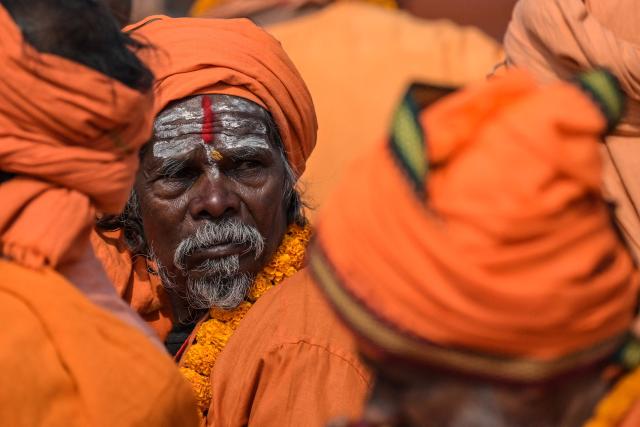 Sadhus or Hindu holy men participate in a ceremony organised to chant 'Bhagavad Gita', a Hindu holy book, in Kolkata on December 7, 2025. (Photo by Dibyangshu SARKAR / AFP)