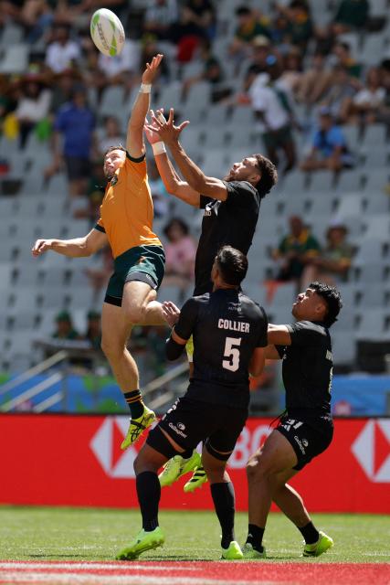 Australia's Josh Turner (L) jumps to get a high ball during the 5th place Semi Final HSBC World Rugby Sevens Series men's rugby match between New Zealand and Australia at the DHL stadium in Cape Town on December 7, 2025. (Photo by GIANLUIGI GUERCIA / AFP)