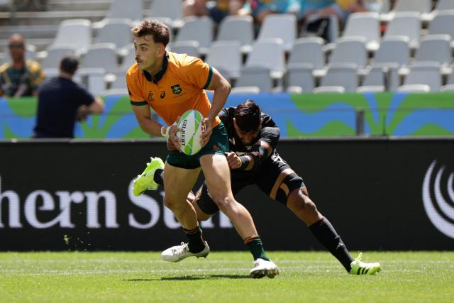 Australia's Jayden Blake is tackled during the 5th place Semi Final HSBC World Rugby Sevens Series men's rugby match between New Zealand and Australia at the DHL stadium in Cape Town on December 7, 2025. (Photo by GIANLUIGI GUERCIA / AFP)