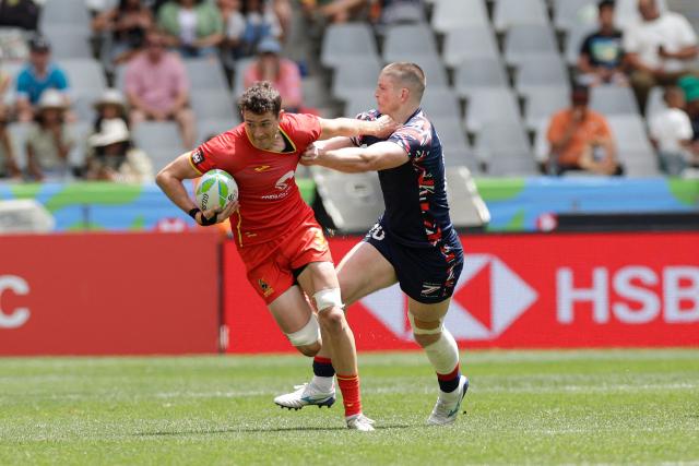 Spain's Angel Bozal fends off a Britain player during the 5th place Semi Final HSBC World Rugby Sevens Series men's rugby match between Spain and Great Britain at the DHL stadium in Cape Town on December 7, 2025. (Photo by GIANLUIGI GUERCIA / AFP)