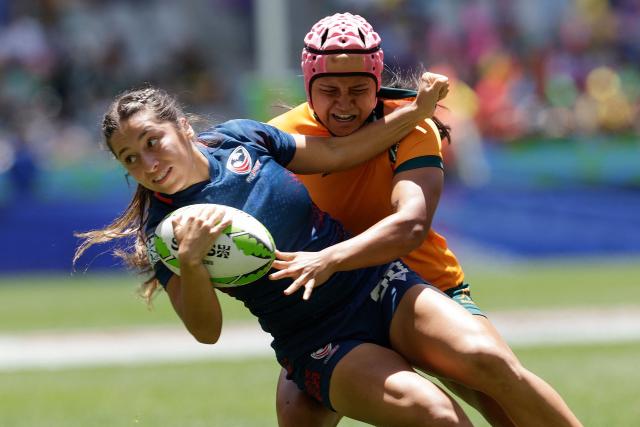 TOPSHOT - USA's Sariah Ibarra is tackled during the Semi Final HSBC World Rugby Sevens Series women's rugby match between Australia and USA at the DHL stadium in Cape Town on December 7, 2025. (Photo by GIANLUIGI GUERCIA / AFP)
