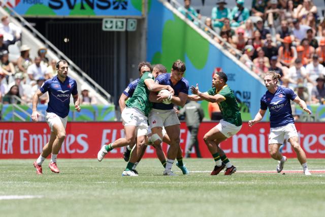 France's Antoine Zeghdar is tackled during the Semi Final HSBC World Rugby Sevens Series men's rugby match between South Africa and France at the DHL stadium in Cape Town on December 7, 2025. (Photo by GIANLUIGI GUERCIA / AFP)