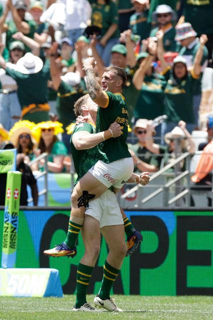 TOPSHOT - South Africa players celebrate their victory against France during the Semi Final HSBC World Rugby Sevens Series men's rugby match between South Africa and France at the DHL stadium in Cape Town on December 7, 2025. (Photo by GIANLUIGI GUERCIA / AFP)