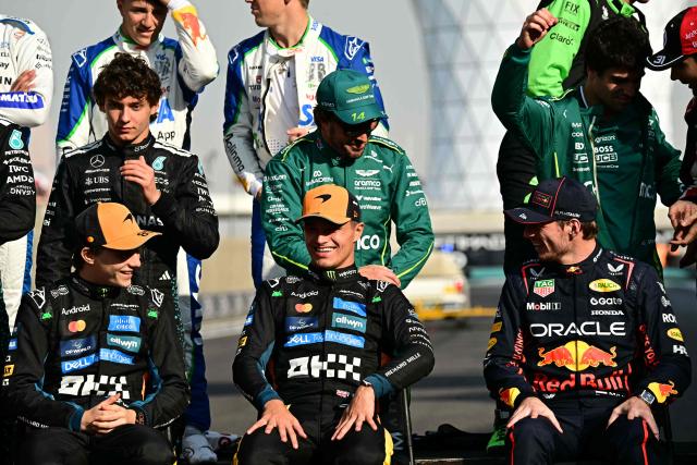 (L-R seated) McLaren's Australian driver Oscar Piastri, McLaren's British driver Lando Norris and Red Bull Racing's Dutch driver Max Verstappen pose for a group photo with other drivers ahead of the Abu Dhabi Formula One Grand Prix at the Yas Marina Circuit in Abu Dhabi on December 7, 2025. (Photo by Giuseppe CACACE / AFP)