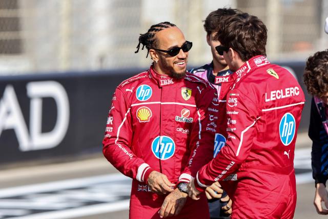 Ferrari's British driver Lewis Hamilton (C) chats with his teammate Ferrari's Monaco driver Charles Leclerc ahead of the Abu Dhabi Formula One Grand Prix at the Yas Marina Circuit in Abu Dhabi on December 7, 2025. (Photo by Fadel SENNA / AFP)