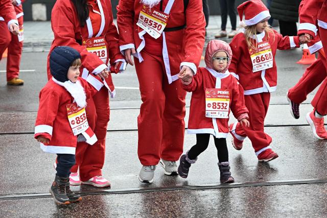 Young participants in Santa Claus costumes take part in the traditional Santa Claus run close to the Danube River in Budapest, Hungary, on December 7, 2025. Around five thousand participants took part in the run for three categories: families with children, amateurs and professional runners. (Photo by Attila KISBENEDEK / AFP)