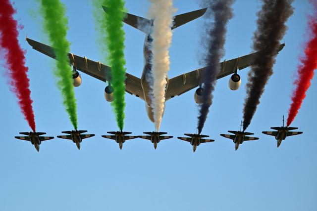 TOPSHOT - An Etihad aircraft accompanied by Emirates jets performs a flyover before the start of the Abu Dhabi Formula One Grand Prix at the Yas Marina Circuit in Abu Dhabi on December 7, 2025. (Photo by Andrej ISAKOVIC / AFP)