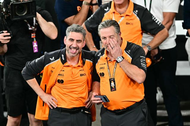 McLaren's Italian team principal Andrea Stella (L) and CEO Zak Brown react after their British driver Lando Norris finished the race third to win the world championship title at the end of the Abu Dhabi Formula One Grand Prix at the Yas Marina Circuit in Abu Dhabi on December 7, 2025. (Photo by Giuseppe CACACE / POOL / AFP)