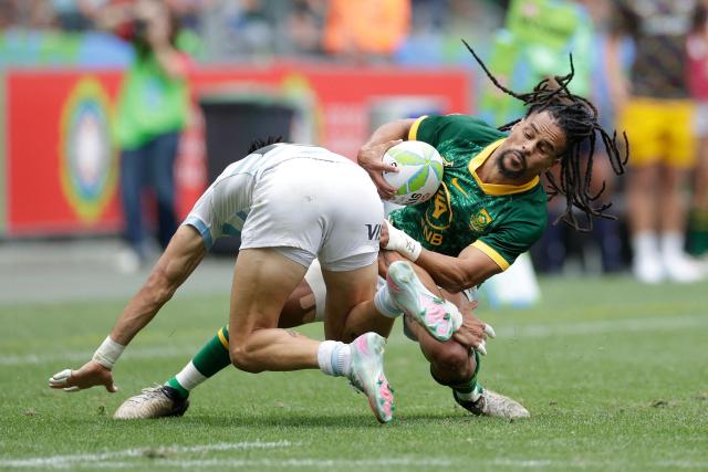 TOPSHOT - South Africa's Selvyn Davids is tackled during the Men's Cup Finals of the HSBC World Rugby Sevens Series men's rugby match between South Africa and Argentina at the DHL stadium in Cape Town on December 7, 2025. (Photo by GIANLUIGI GUERCIA / AFP)