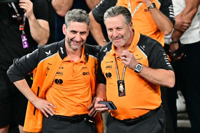 McLaren's Italian team principal Andrea Stella (L) and CEO Zak Brown react after their British driver Lando Norris finished the race third to win the world championship title at the end of the Abu Dhabi Formula One Grand Prix at the Yas Marina Circuit in Abu Dhabi on December 7, 2025. (Photo by Giuseppe CACACE / POOL / AFP)