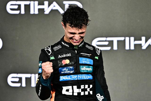 TOPSHOT - World champion and race third-placed McLaren's British driver Lando Norris celebrates on the podium at the end of the Abu Dhabi Formula One Grand Prix at the Yas Marina Circuit in Abu Dhabi on December 7, 2025. (Photo by Giuseppe CACACE / AFP)