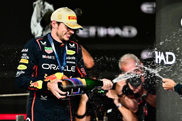Race winner Red Bull Racing's Dutch driver Max Verstappen celebrates on the podium at the end of the Abu Dhabi Formula One Grand Prix at the Yas Marina Circuit in Abu Dhabi on December 7, 2025. (Photo by Giuseppe CACACE / AFP)