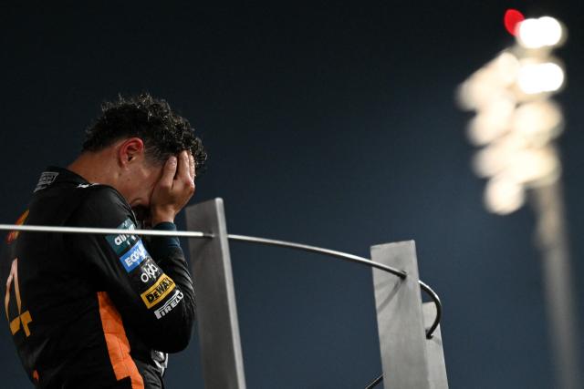 McLaren’s British driver Lando Norris celebrates on the podium after finishing the race third to win the world championship title at the end of the Abu Dhabi Formula One Grand Prix at the Yas Marina Circuit in Abu Dhabi on December 7, 2025. (Photo by Andrej ISAKOVIC / AFP)