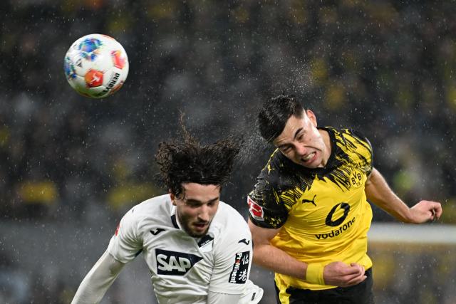Hoffenheim's Swiss midfielder #07 Leon Avdullahu (L) and Dortmund's Argentinian defender #28 Aaron Anselmino vie a header during the German first division Bundesliga football match between BVB Borussia Dortmund and TSG 1899 Hoffenheim in Dortmund, western Germany, on December 7, 2025. (Photo by UWE KRAFT / AFP) / DFL REGULATIONS PROHIBIT ANY USE OF PHOTOGRAPHS AS IMAGE SEQUENCES AND/OR QUASI-VIDEO