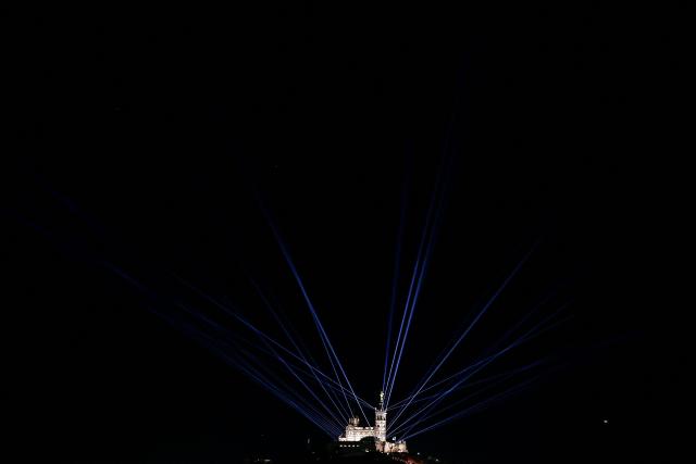 This photograph taken on December 7, 2025 shows a sound and light show origanised to celebrate the inauguration of the statue of the Virgin Mary atop the Basilica of Notre-Dame de la Garde, known to the people of Marseille as Bonne Mere, after its restoration, in Marseille, southern France. (Photo by Thibaud MORITZ / AFP)
